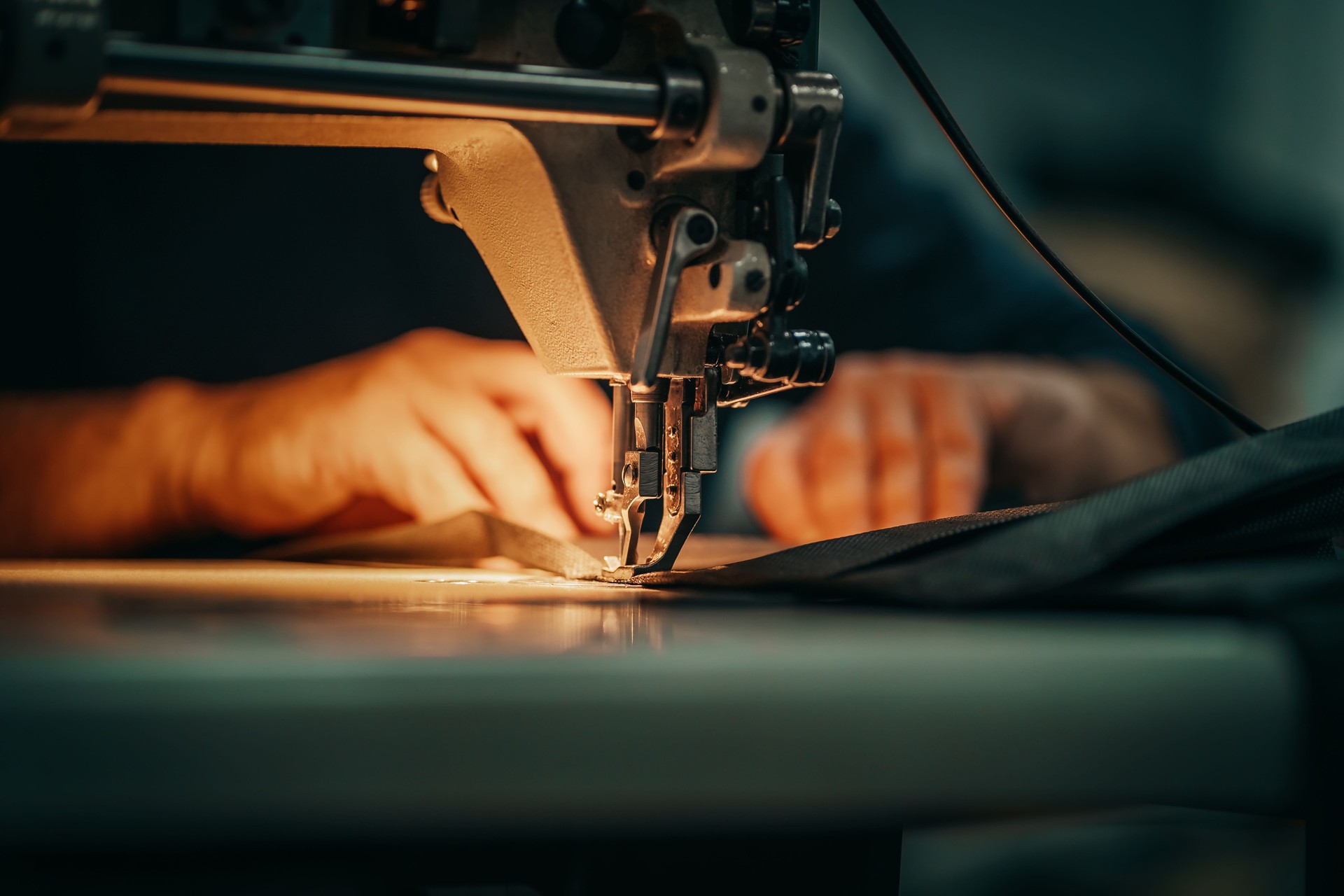 Sewing machine and men's hands of a tailor